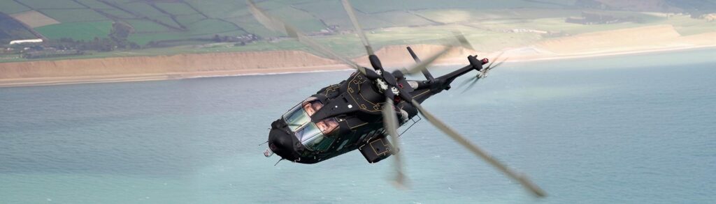 AgustaWestland AW101 helicopter flying low over a moor at dusk