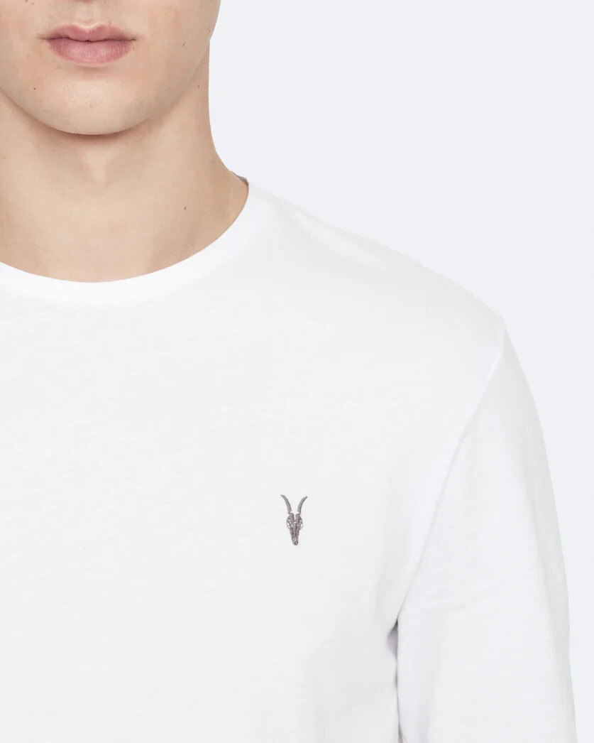 White long-sleeve undershirt folded beside a grey wool sweater