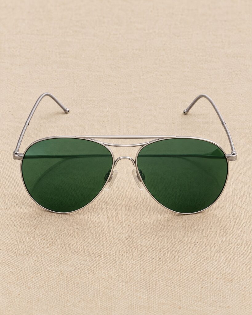 Vintage American Optical AN-6531 style aviator sunglasses with green lenses on canvas