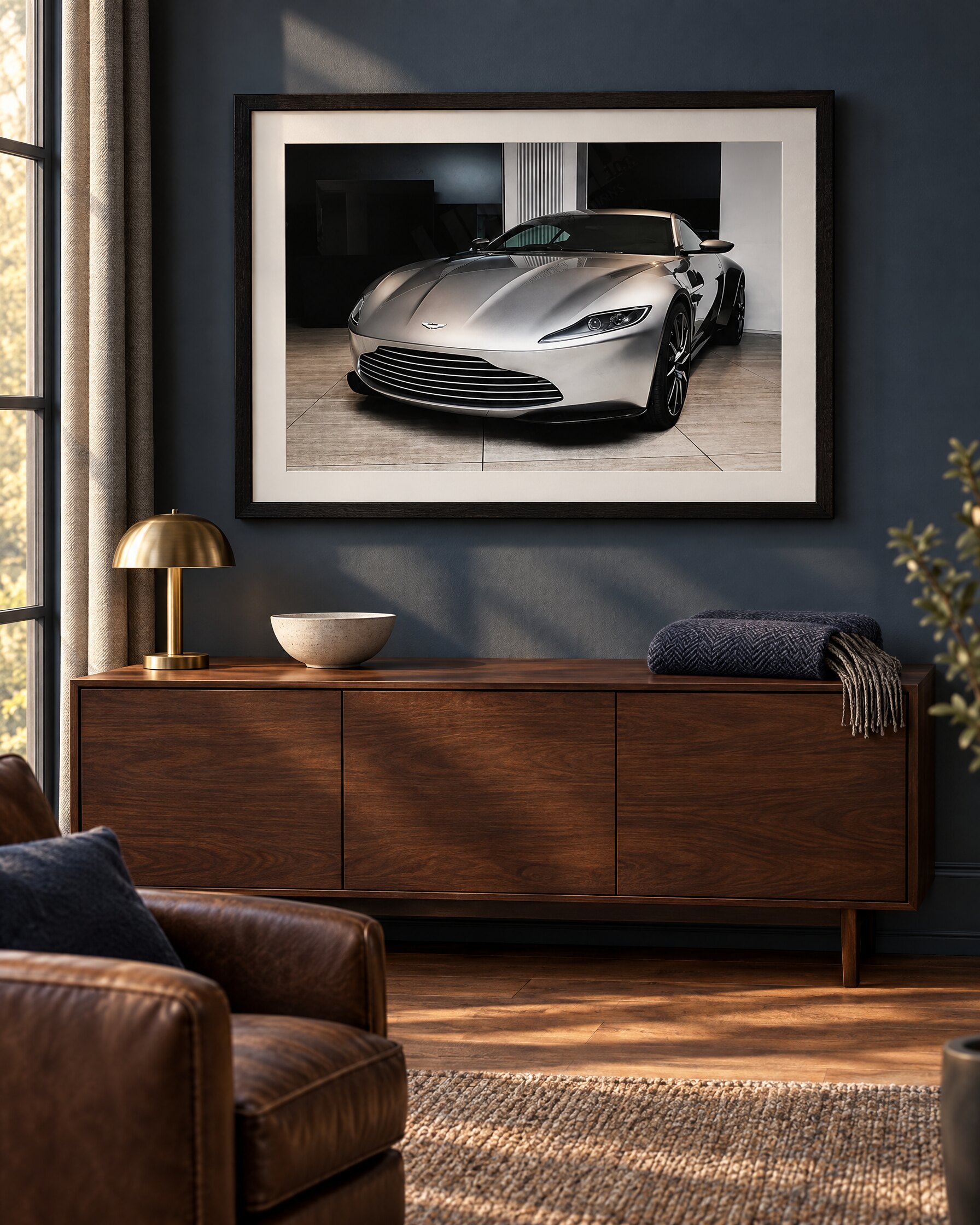 Large framed photograph of an Aston Martin DB10 hung above a walnut console in a quiet study