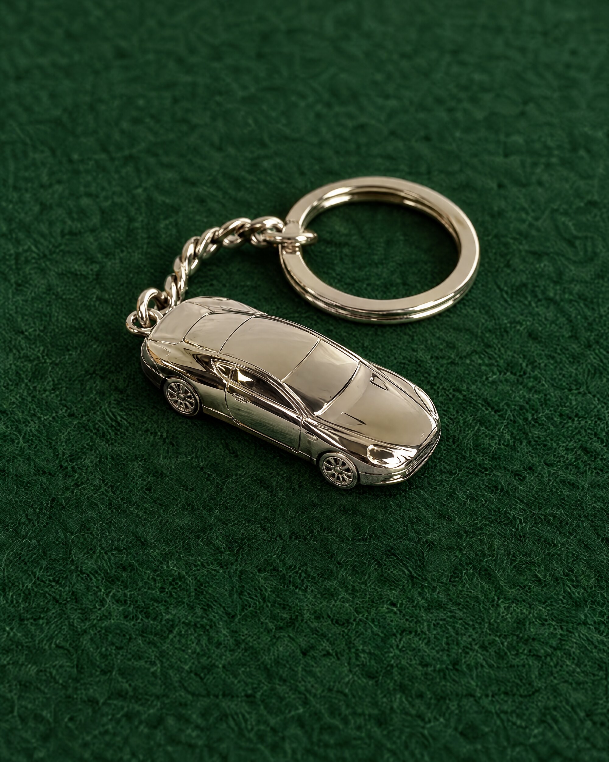 Aston Martin DB9 keyring in solid silver on green baize
