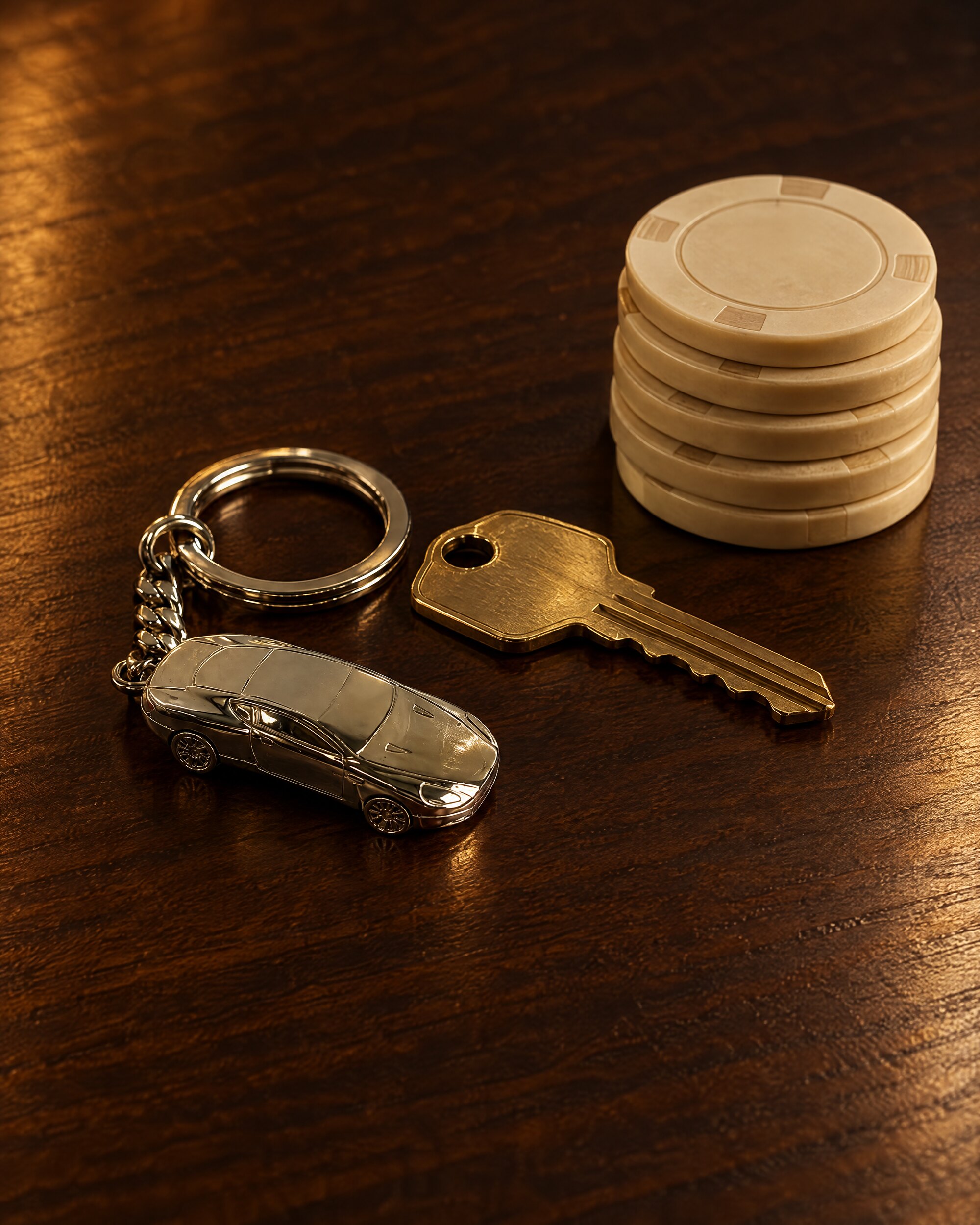 Silver DB9 keyring beside a brass key and plain chips on a wooden table