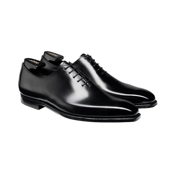Black wholecut Oxford shoes on a charcoal cloth with a shoe horn