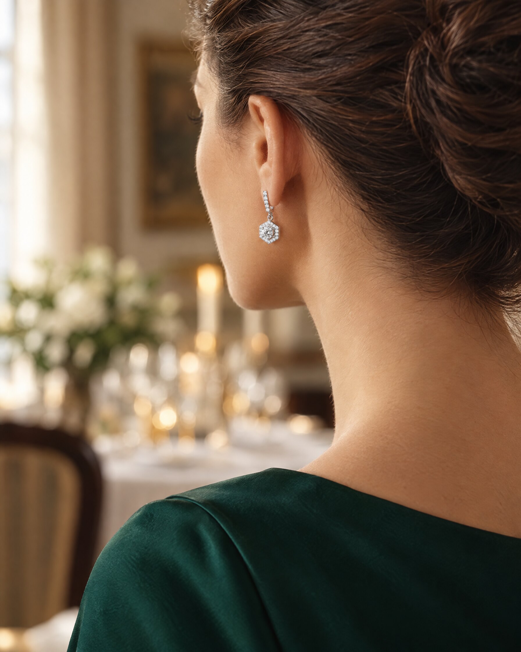 Hexagon drop earrings in sterling silver worn with a dark green evening dress, shown from behind in soft evening light