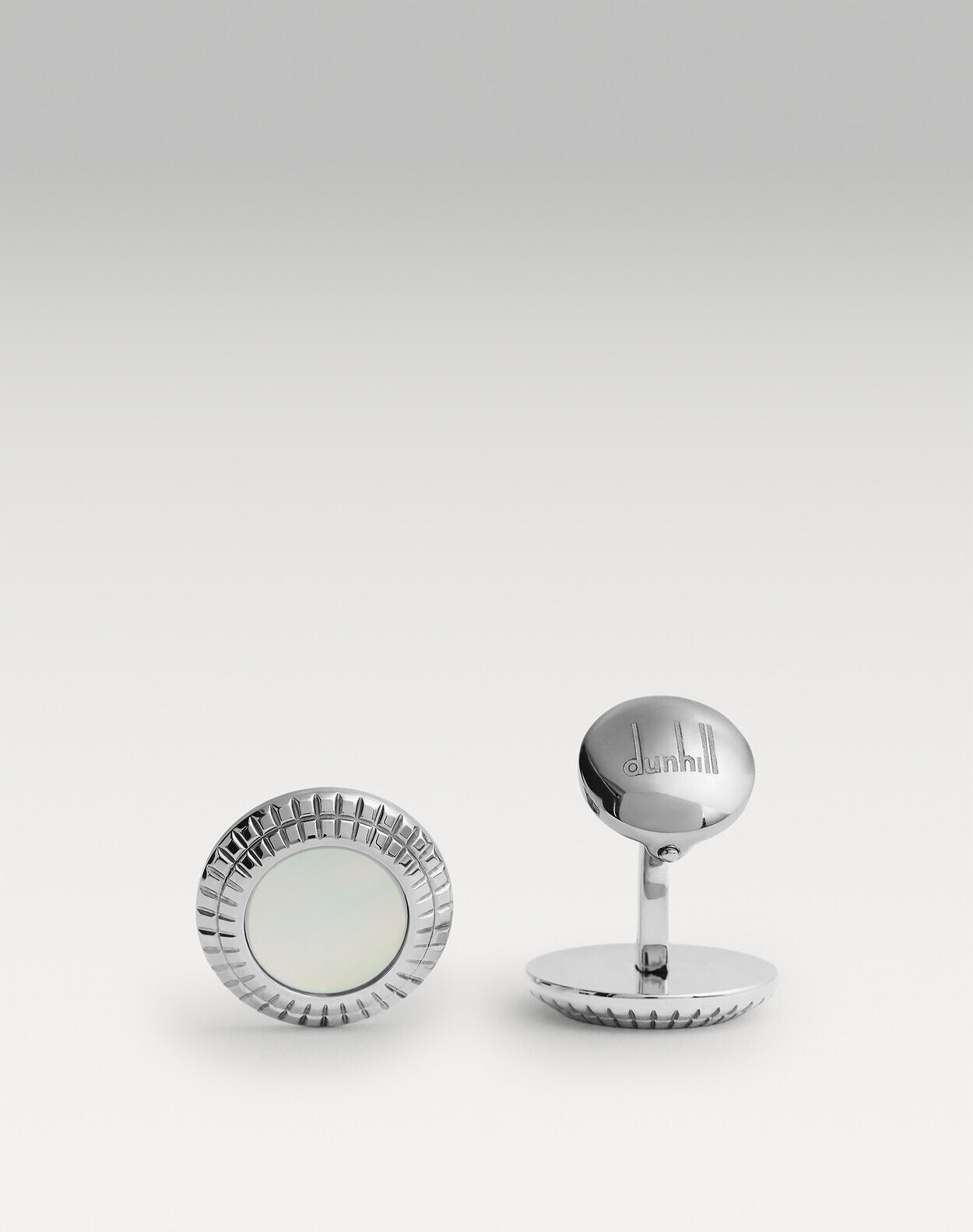 Dunhill style L-shaped metal cufflinks on a white double cuff