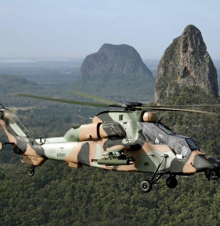 Eurocopter Tiger style attack helicopter hovering over a grey sea