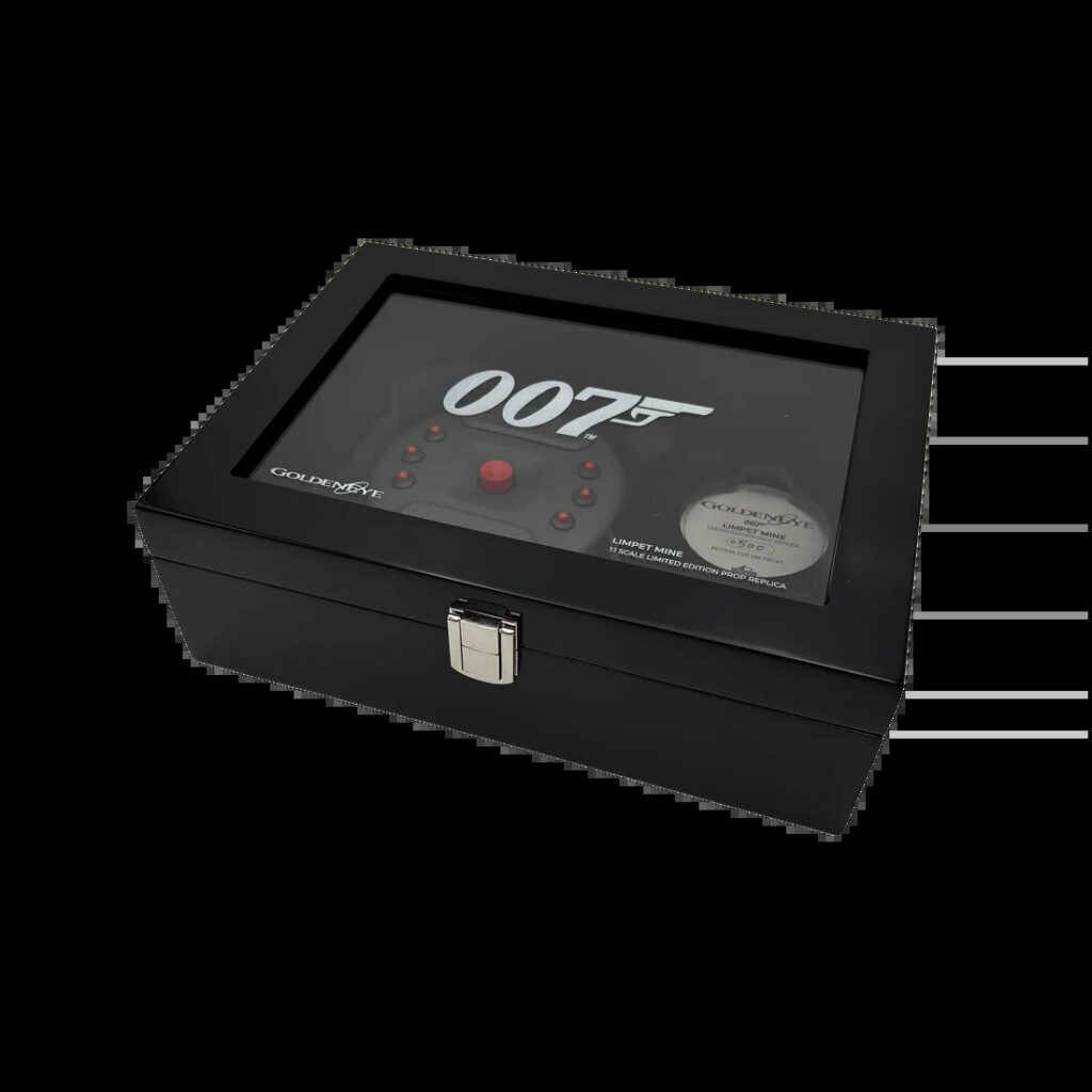 Brushed aluminium frame with amber lens on a display stand beside two gold keys