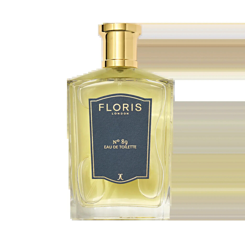 Glass eau de toilette bottle on a walnut tray beside a handkerchief and lavender