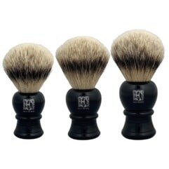Black-handled badger hair shaving brush on white marble