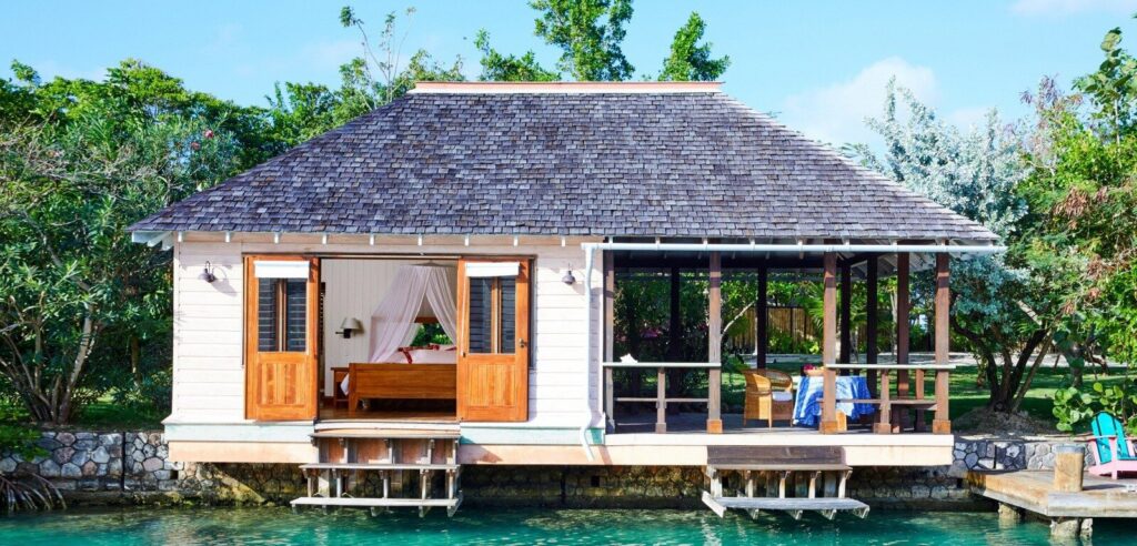 Whitewashed villa above a private cove in a tropical garden, in the spirit of GoldenEye Jamaica
