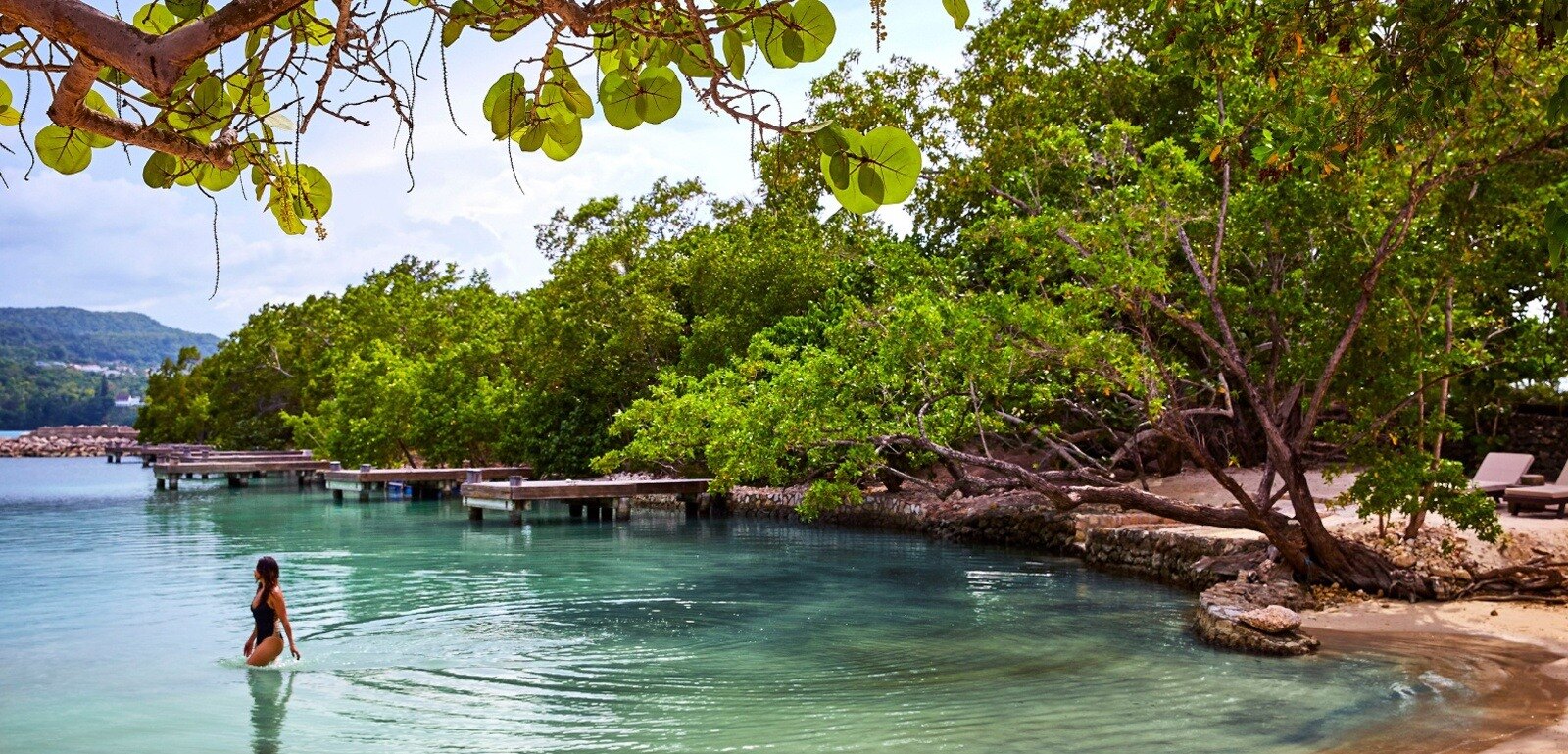 Whitewashed villa above a private cove in a tropical garden, in the spirit of GoldenEye Jamaica