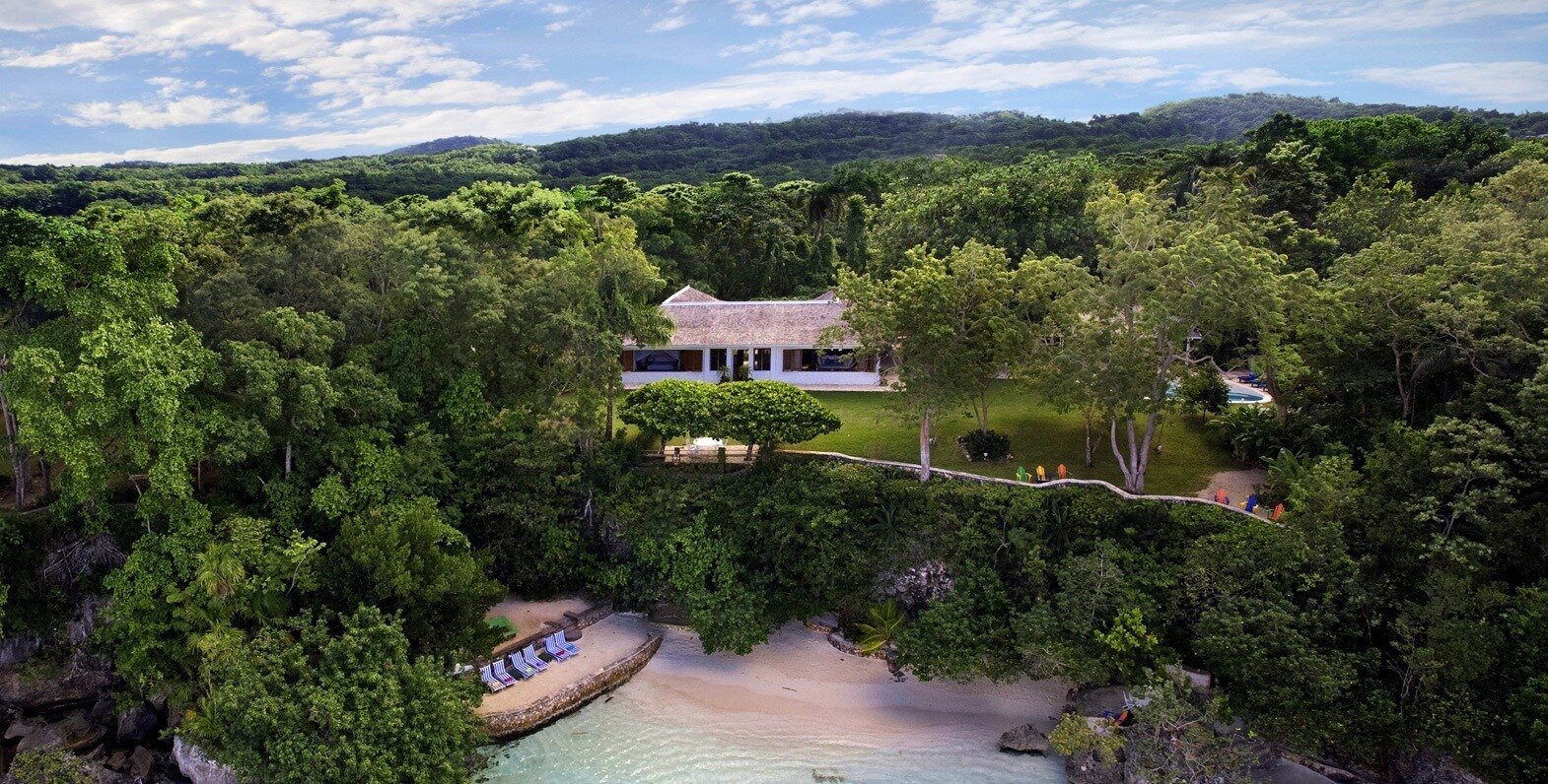 Low tropical house with jalousie shutters, pool and beach in Jamaica