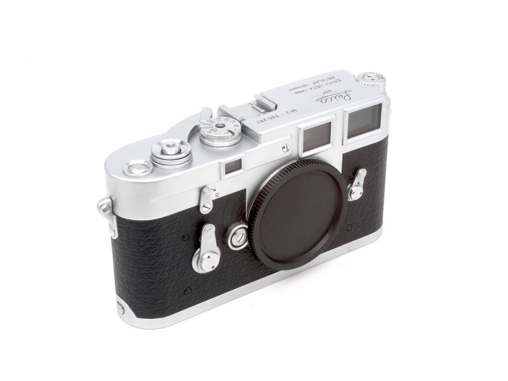 Chrome 35mm rangefinder camera on green leather, the Leica M3 in a quiet setting
