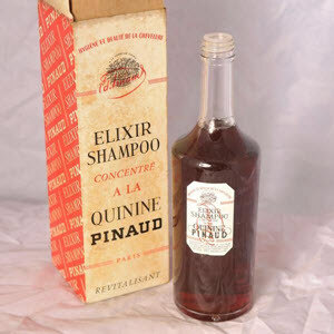Vintage amber glass shampoo bottle on a white tiled shelf