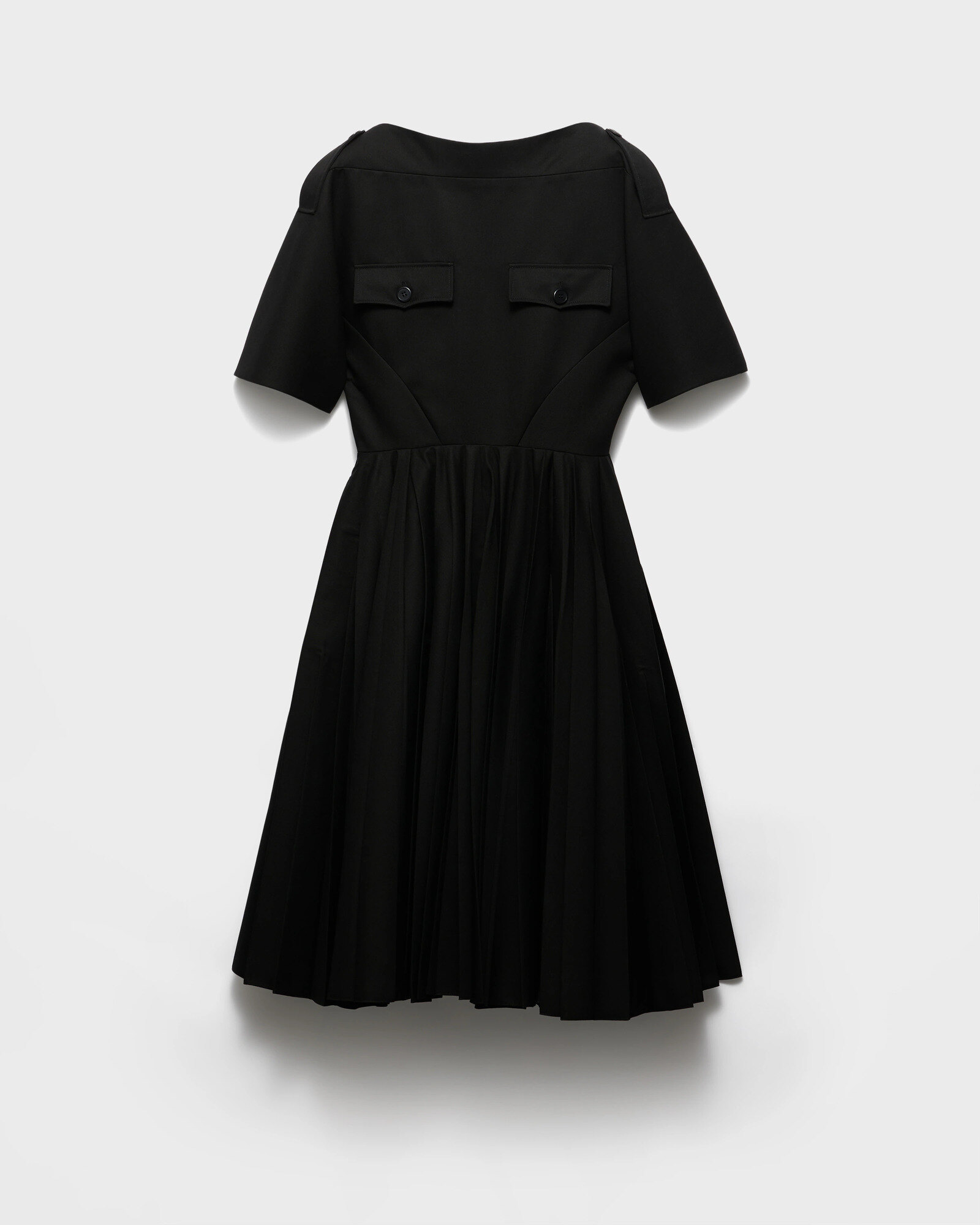 Plain black cocktail dress laid flat with black leather flats, in the spirit of the Prada black dress from Quantum of Solace