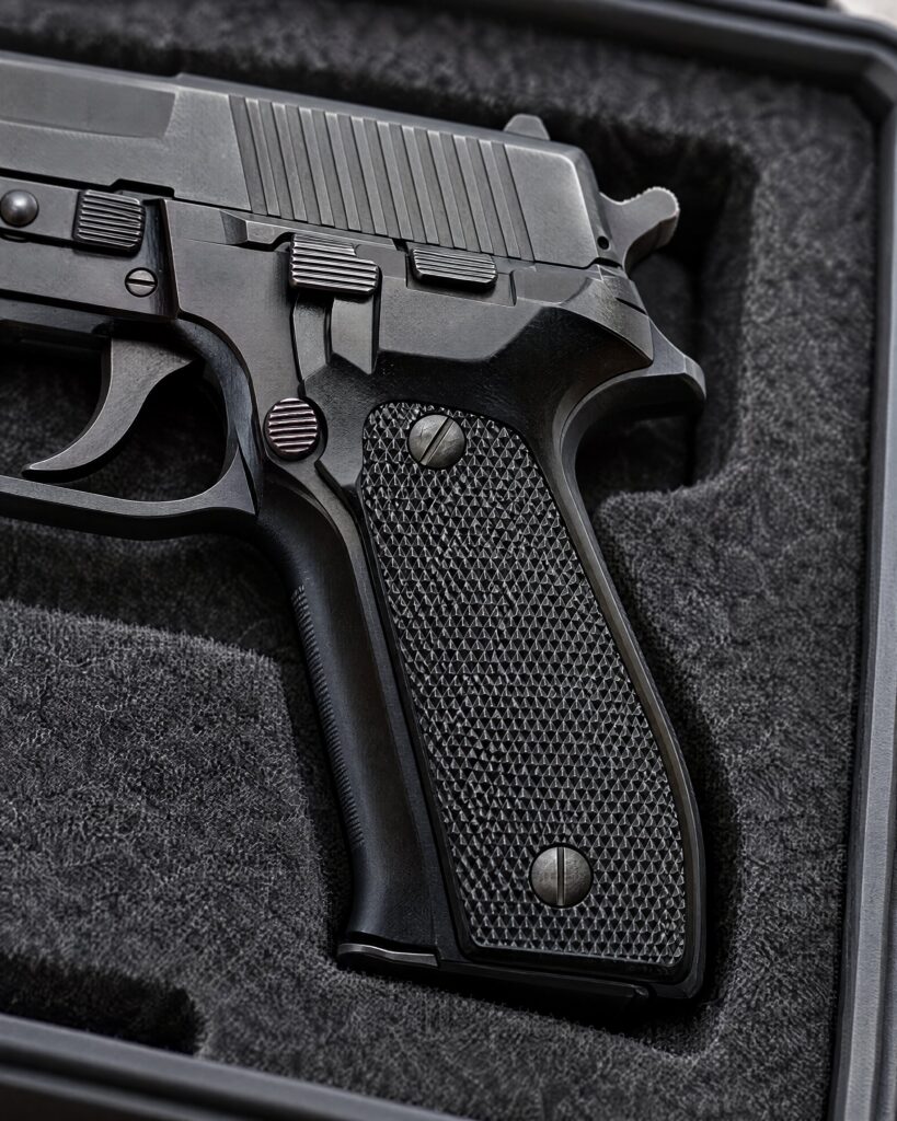 Detail of a black service pistol grip in a felt-lined case