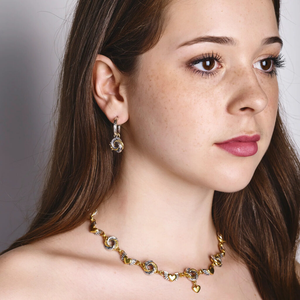 Sophie Harley Algerian Love Knot earrings, silver stud with gold detail, close-up on linen