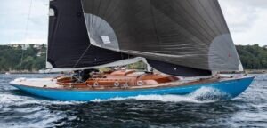 Bow and foredeck detail of a Spirit 46 yacht with dark blue hull and varnished timber trim