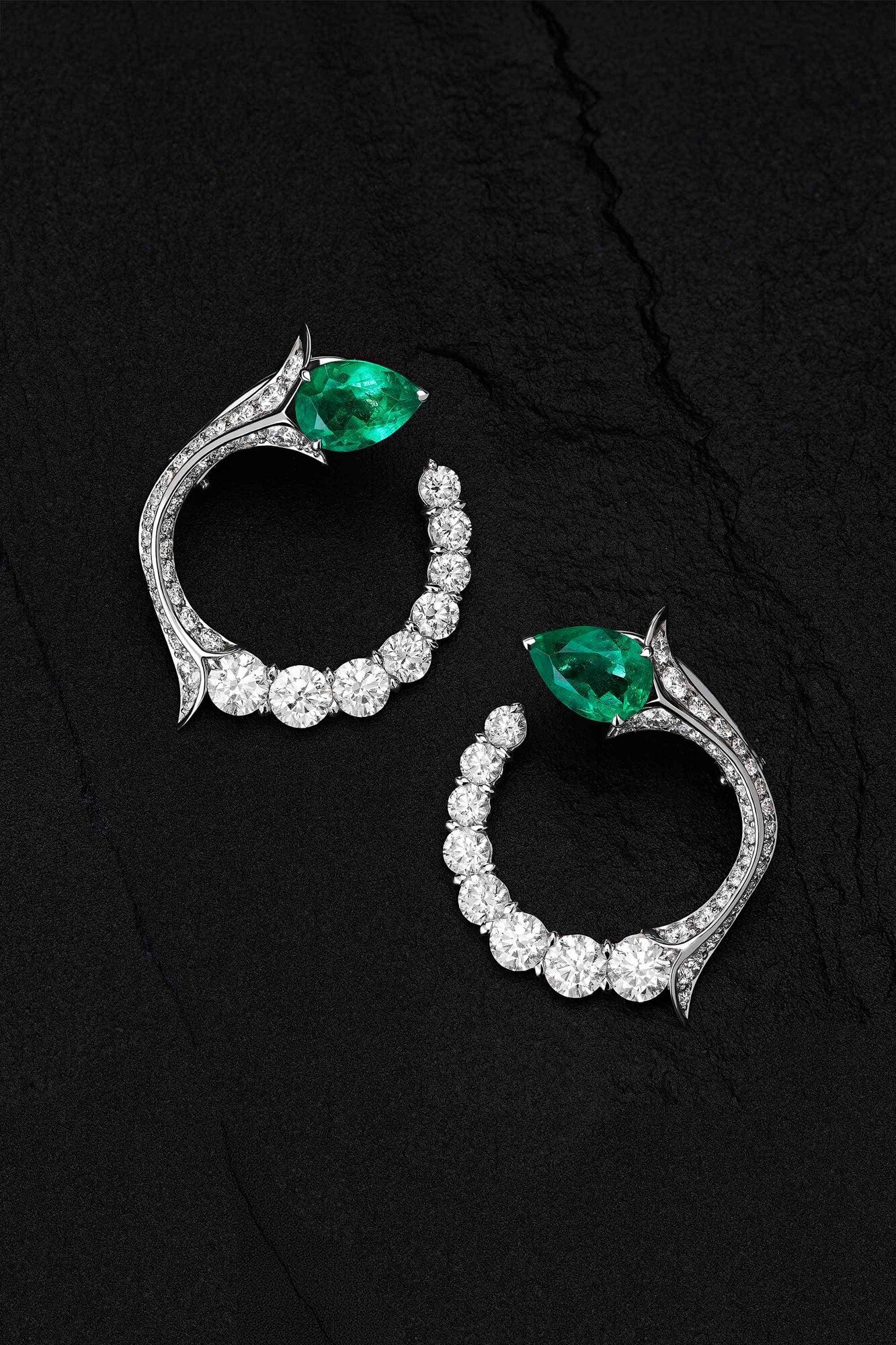 Pendant diamond earrings and cocktail ring on dark velvet
