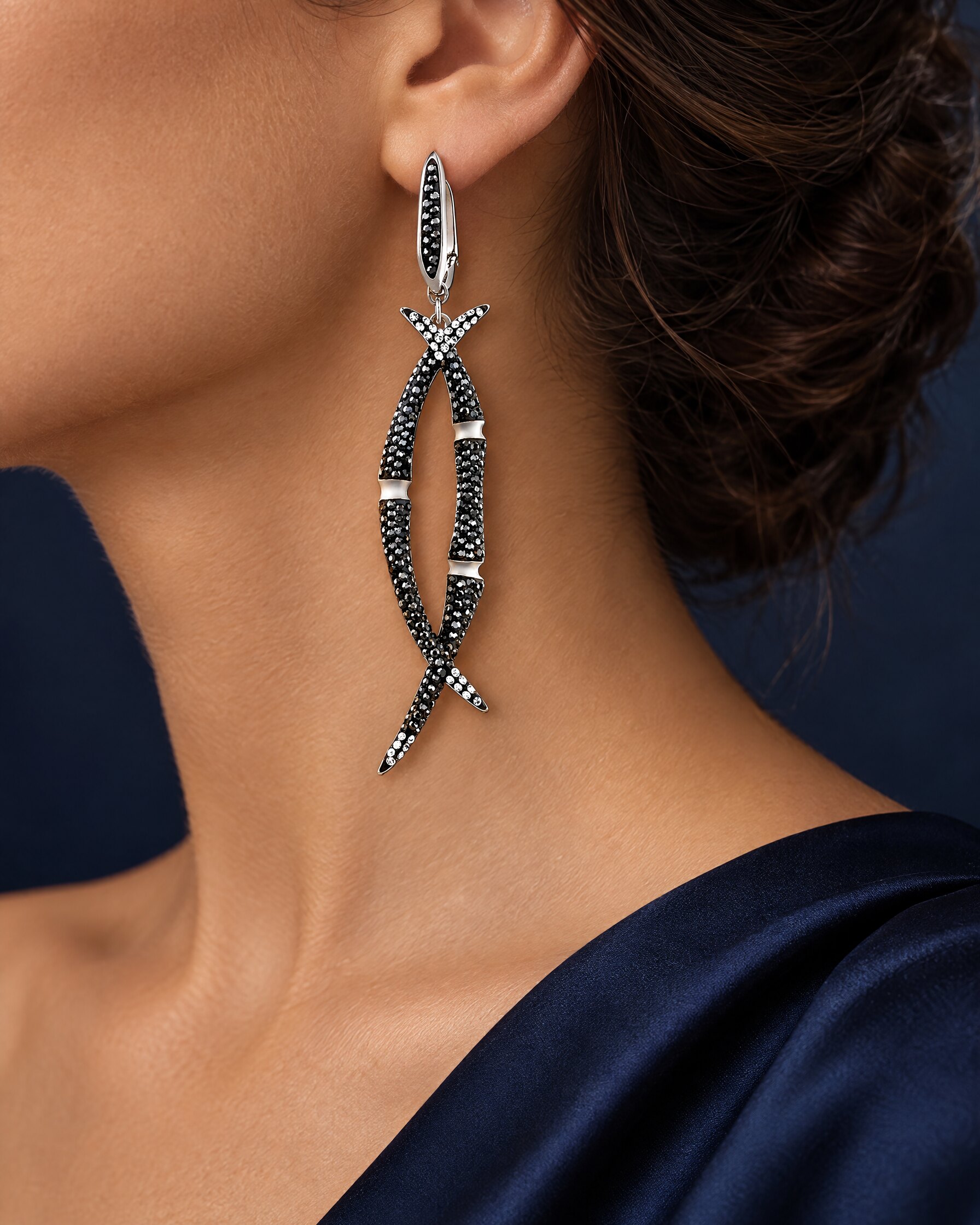 Long black crystal drop earring worn with swept-up hair and a navy silk dress