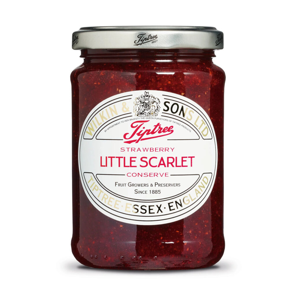 Jar of Tiptree Little Scarlet strawberry jam beside buttered toast