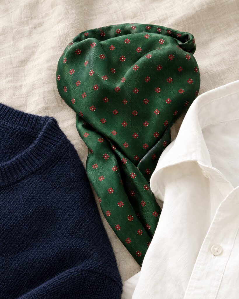 Green silk Tootal-style day cravat folded beside a navy jumper