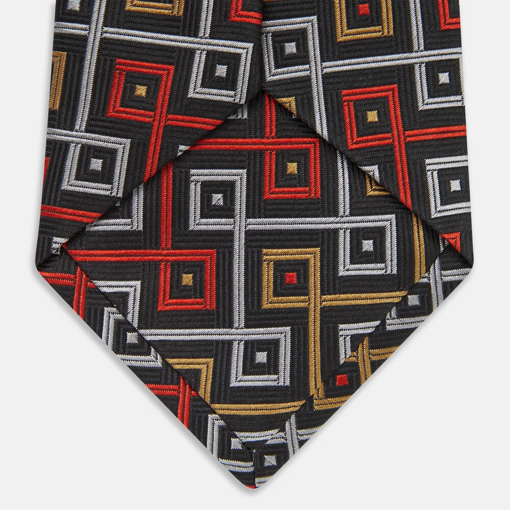 Dark silk necktie with interlocking squares laid on pale linen