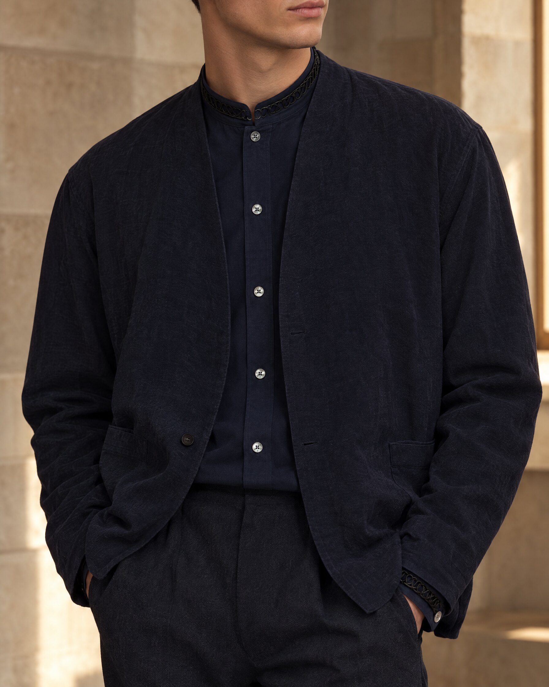 Man wearing a Wooyoungmi navy shirt from Spectre with lace collar under a navy jacket